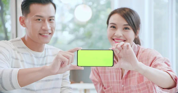アジアの男性と女性は緑の画面で5Gのフルディスプレイ携帯電話の情報を表示します — ストック写真