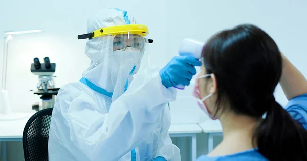 Mujer Médico Utiliza Pistola Termómetro Frente Infrarroja Para Comprobar Temperatura —  Fotos de Stock