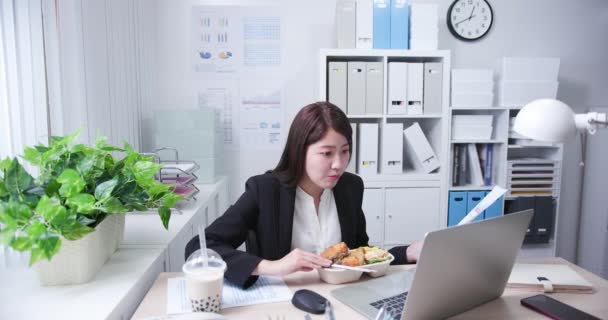 Vrouw eet lunch en werk — Stockvideo