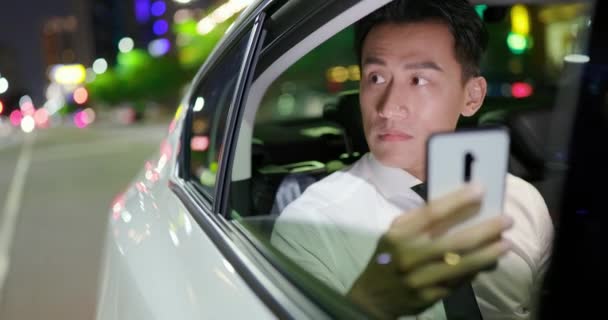 Бизнесмен пользуется телефоном в машине — стоковое видео