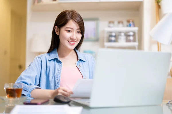 アジアのビジネス女性は自宅で働くためにラップトップコンピュータとスマートフォンを使用しています — ストック写真