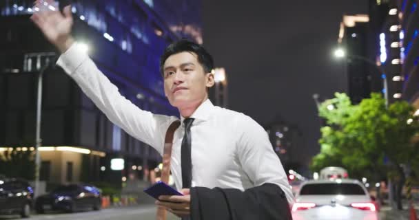 Aziatische zakenman bel de taxi — Stockvideo