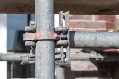 kilitleme mekanizması bir villa yapım aşamasında, arka planda çevresinde bazı tuğla yapı iskelesi bir ayrıntı olarak görülebilir