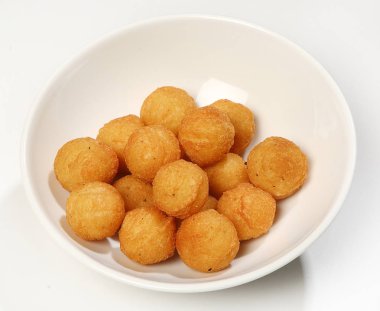 Patates topları beyaz bir arka plan beyaz bir tabağa garnitür.