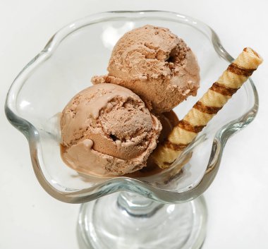 Çikolatalı dondurma cam vazoda beyaz bir arka plan üzerinde yakın çekim.