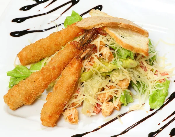 Caesar salad with shrimp, iceberg salad, tomatoes, cheese and croutons.