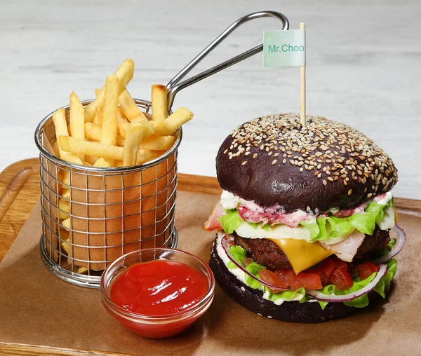 Burger bir ahşap tahta üzerinde sığır eti, patates kızartması, sos ile.