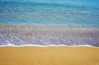 Kumlu sahilde denizin yumuşak dalgası.