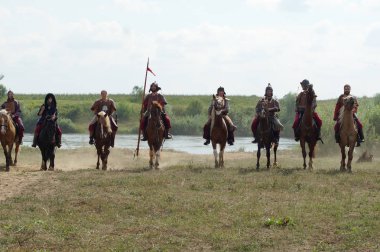 RUSSIA, KALUGA REGION, DZERZHINSKY DISTRICT, DVORTSY - JUL 14, 2018: Reconstruction of military operations in 1480. Riders on the horses with weapons clipart