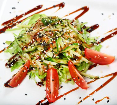 Yılan balıklı salata, salatalık, bir tabak marullu domates..