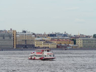 yolcu tekne Neva nehir boyunca tarihi waterfront arka plan üzerinde atılıyor.