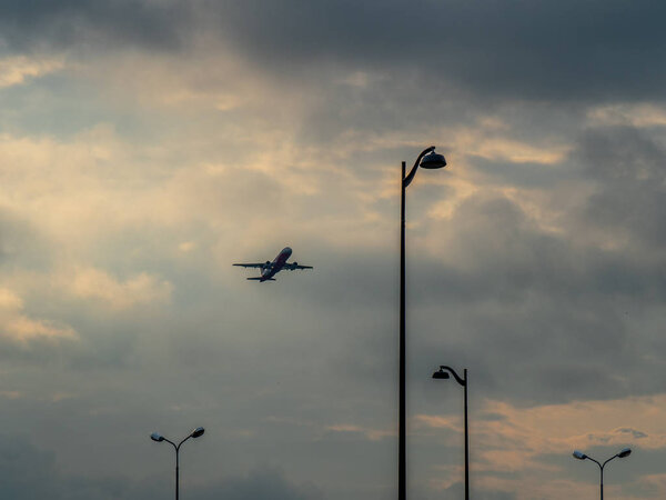 the plane takes off through the clouds and clouds on the background of lights