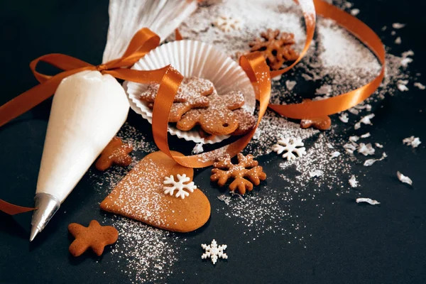 圣诞姜饼饼干与糖果乳酪雪片和糕点袋与结冰的黑色背景 假日食品 自制烘焙 圣诞节和新年传统 — 图库照片#