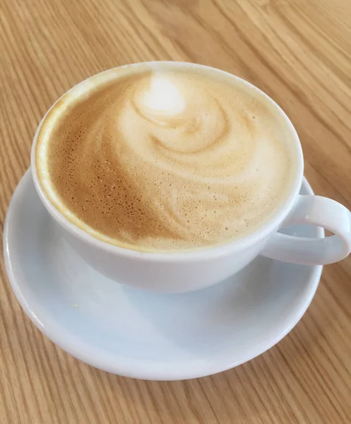 Xícara de café cappuccino na mesa de madeira — Fotografia de Stock