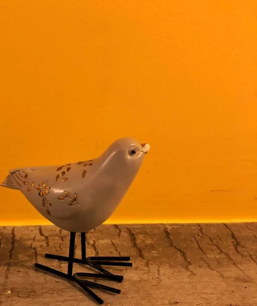 Souvenir-Vogel auf orangefarbenem Hintergrund mit Platz für Text — Stockfoto