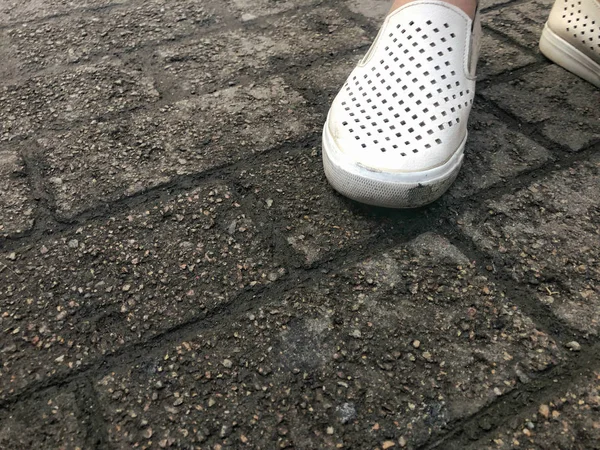Πόδια σε λευκά παπούτσια σε πλάκες — Φωτογραφία Αρχείου