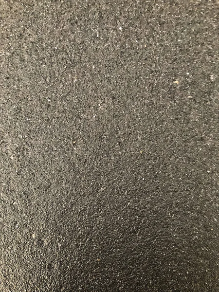 Düz koyu gri asfalt kaplama doku küçük kayalar ile