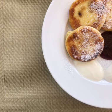 Süzme peynirli krep ya da ahududu reçeli beyaz tabakta, yakın görüş. Rus, Ukrayna mutfağı. Sağlıklı lezzetli kahvaltı.