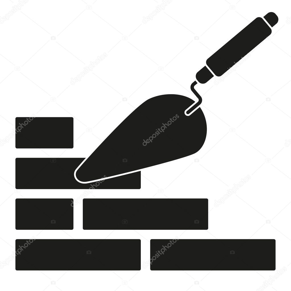 Black and white trowel silhouette on brick wall