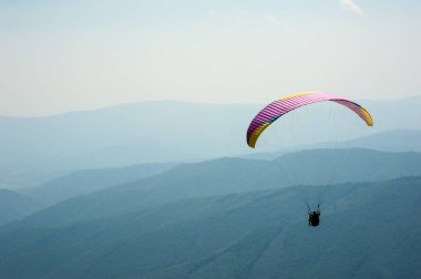 Yamaçparaşütü bir güneşli yaz gününde bir dağ Vadisi uçar. Karpatlar yaz aylarında yapılan yamaç paraşütü.