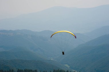 Yamaçparaşütü bir güneşli yaz gününde bir dağ Vadisi uçar. Karpatlar yaz aylarında yapılan yamaç paraşütü.