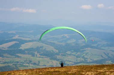Yamaçparaşütü Karpat Dağları'nda dağın üzerinden kapalı alır. Yaz aylarında Dağları'nda yamaç paraşütü.