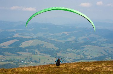Yamaçparaşütü Karpat Dağları'nda dağın üzerinden kapalı alır. Yaz aylarında Dağları'nda yamaç paraşütü.