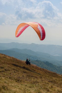 Bir yamaçparaşütü uçmak bir dağ Vadisi bir güneşli yaz gününde. Karpatlar yaz aylarında yapılan yamaç paraşütü.