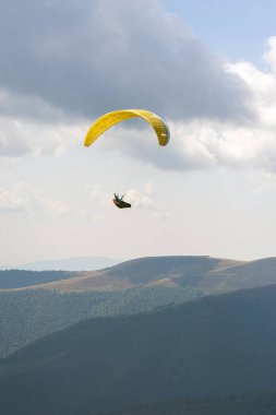 Bir yamaçparaşütü uçmak bir dağ Vadisi bir güneşli yaz gününde. Karpatlar yaz aylarında yapılan yamaç paraşütü.