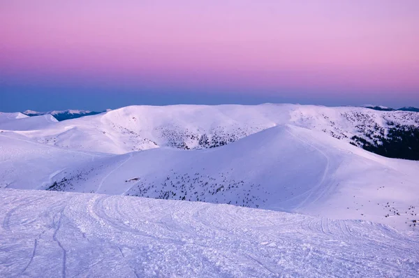 Kışın şaşırtıcı gündoğumu dağlarda. Kış soğuk sabah güneşin ışınları dağlarda zirveleri karla kaplı.