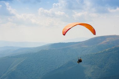 Yamaçparaşütü uçmak bir dağ Vadisi bir güneşli yaz gününde. Karpatlar yaz aylarında yapılan yamaç paraşütü.