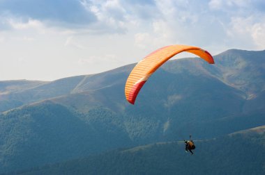 Yamaçparaşütü uçmak bir dağ Vadisi bir güneşli yaz gününde. Karpatlar yaz aylarında yapılan yamaç paraşütü.