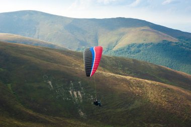 Yamaçparaşütü uçmak bir dağ Vadisi bir güneşli yaz gününde. Karpatlar yaz aylarında yapılan yamaç paraşütü.