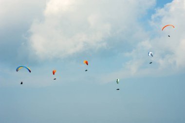 Yamaç paraşütü güneşli mavi gökyüzünde. Paraşütler sinek Karpatlar yaz güneşli bir günde gurup. Paraşütler bulutlar arka planı.