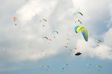 Yamaç paraşütü güneşli mavi gökyüzünde. Paraşütler sinek Karpatlar yaz güneşli bir günde gurup. Paraşütler bulutlar arka planı.