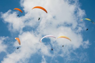 Yamaç paraşütü güneşli mavi gökyüzünde. Paraşütler sinek Karpatlar yaz güneşli bir günde gurup. Paraşütler bulutlar arka planı.