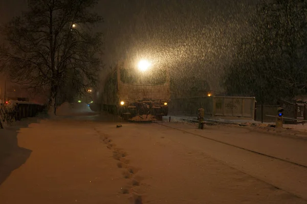 Train on the railway in heavy snow storm at night. Passenger train moves on the railway in winter in Ukraine.