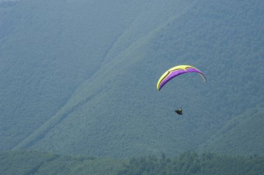 Yamaçparaşütü uçmak bir dağ Vadisi bir güneşli yaz gününde. Karpatlar yaz aylarında yapılan yamaç paraşütü.