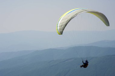 Yamaçparaşütü uçmak bir dağ Vadisi bir güneşli yaz gününde. Karpatlar yaz aylarında yapılan yamaç paraşütü.