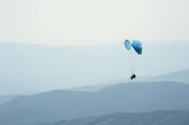 Yamaçparaşütü uçmak bir dağ Vadisi bir güneşli yaz gününde. Karpatlar yaz aylarında yapılan yamaç paraşütü.