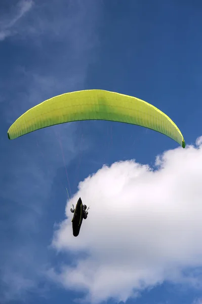 Parapente amarelo e verde está voando no céu azul contra th — Fotografia de Stock