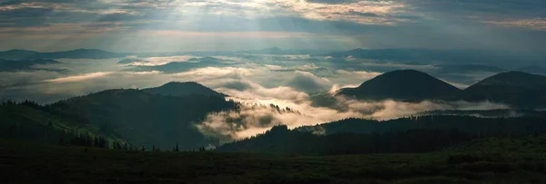 Surpreendente nascer do sol nas montanhas. Excelente vista do vale nebuloso com raios de sol brilhantes em Cárpatos . — Fotografia de Stock