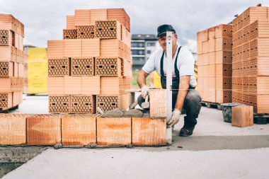 Sanayi işçisi mala ve çekiç tuğla ve harç dış duvarları oluşturmak için kullanma