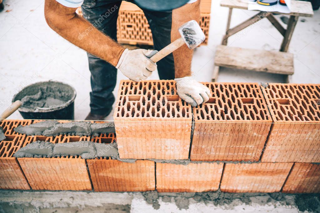 close up details of construction site worker building brick walls