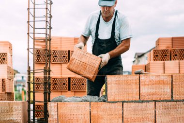 professional, portrait of industrial worker building walls with ceramic bricks clipart