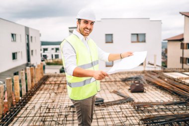 Portrait of confident and smiling man, engineer working on construction site clipart