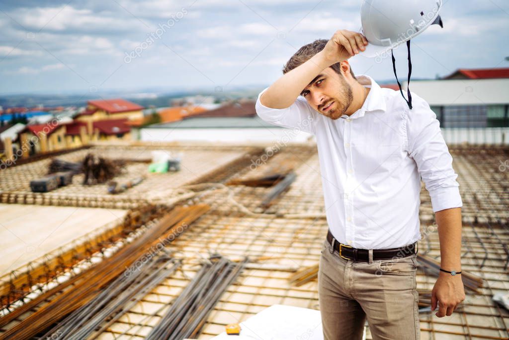 Portrait of architect on construction site with hardhat. 