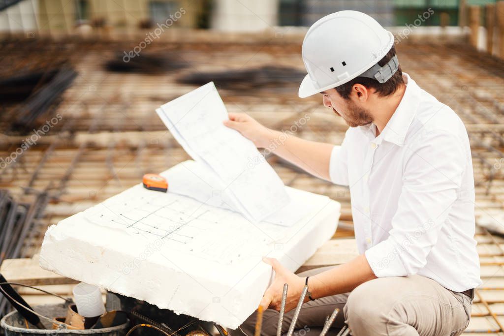 close up portrait of engineer reading plans on construction site