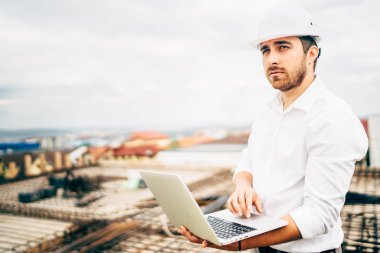 Emin genç gülümseyen ve inşaat inşaat kontrol mühendisi İnşaat