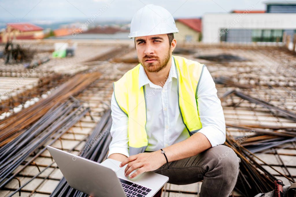 engineer using laptop on construction site. Industry details